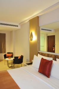 une chambre d'hôtel avec un lit et une chaise dans l'établissement Pyrenees Jogja, à Yogyakarta