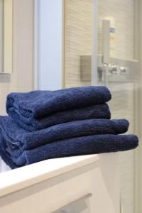 une pile de serviettes bleues assises sur un comptoir dans une salle de bains dans l'établissement Appartement Gambetta, à Saint-Jean-de-Luz 33 autres photos