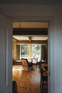 uma sala de estar com uma mesa e cadeiras e uma janela em Lūķi, Lauku sēta em Jūrkalne