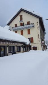 un edificio con nieve encima en Hôtel Restaurant de la poste, en Saint-Colomban-des-Villards