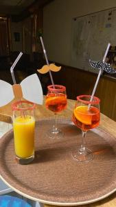 - un plateau avec quatre verres de jus d'orange sur une table dans l'établissement Hôtel Restaurant de la poste, à Saint-Colomban-des-Villards