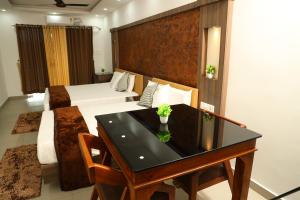 een hotelkamer met een tafel en een bed bij Green Valley Residency in Kattappana