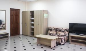 uma sala de estar com um armário e um sofá em Sokol Hotel em Sochi