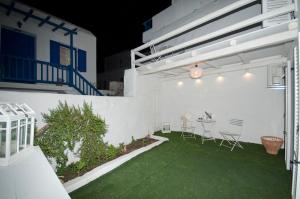 a patio with a table and chairs on a green lawn at Mykonos Marina in Mikonos