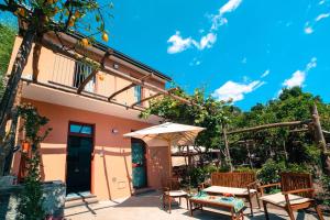 a patio with a table and chairs and an umbrella at Poggio Angelarosa: Lemon Garden Stay&Relax in Scala