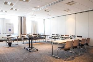 a conference room with tables and chairs and a whiteboard at Novotel Marseille Est Porte d'Aubagne in Marseille +110 photos