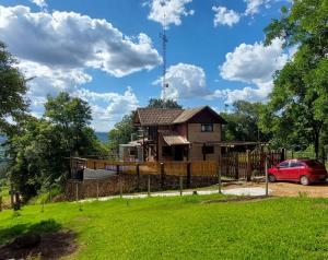 a house with a fence in front of a yard at Chalé da Serra in Bragança Paulista