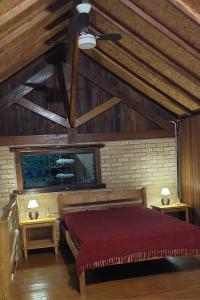 a bedroom with a red bed and two tables at Chalé da Serra in Bragança Paulista +21 photos