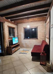 a living room with a couch and a tv at Chalé da Serra in Bragança Paulista