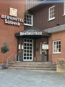 a red brick building with a restaurant sign on it at Berghotel Sülbeck in Nienstädt