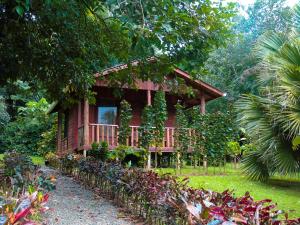 Cataratas Bijagua Lodge, incluye tour autoguiado Bijagua Waterfalls Hike في بيجاغوا: منزل احمر في وسط غابه