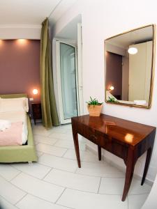 uma sala de estar com uma mesa e um espelho em Soraya em Nápoles