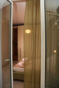 uma porta de vidro deslizante que leva a um quarto com uma cama em Soraya em Nápoles
