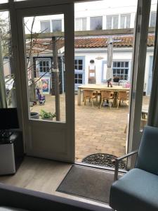 an open door to a patio with a table at B&B Zee van Tijd Domburg in Domburg