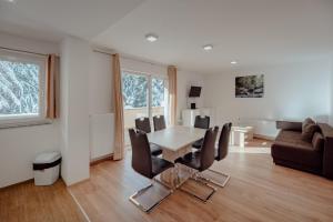 Una sala de estar con una mesa y sillas y un sofá. en Apartments Gozd Martuljek, en Kranjska Gora