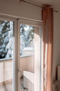 una puerta corredera de cristal que da a un balcón con nieve en Apartments Gozd Martuljek, en Kranjska Gora 81 fotos más