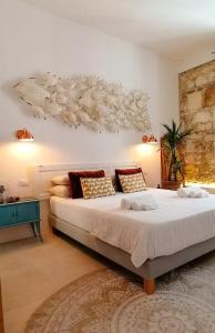 een slaapkamer met een groot bed met een witte sprei bij Calamùrn Ortigia in Siracusa