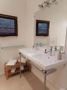 a bathroom with a white sink and a mirror at La Longère des Olonnes in Les Sables-d'Olonne