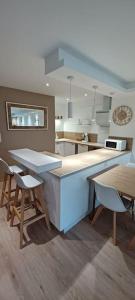 a kitchen with a counter and a table and chairs at Gîte "La bulle de Léna" avec petit-déjeuner garage et parking in Flavigny