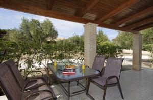a table and four chairs on a patio at Liostasi Village in Vasilikos