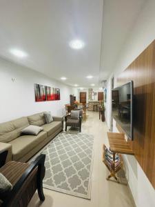 een woonkamer met een bank en een flatscreen-tv bij Apartamento Aquaville Resort in Aquiraz