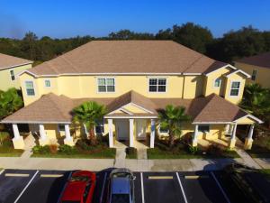 a large yellow house with cars parked in a parking lot at Serenity Resort 3 Bedroom Vacation Townhome with Pool (2008) in Clermont