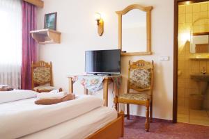 ein Hotelzimmer mit 2 Betten und einem TV in der Unterkunft Landgasthof Zum Hirschen in Kemnath