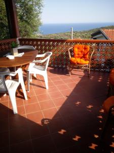 patio con tavolo e sedie su una terrazza di Baia Luna a Marina di Camerota