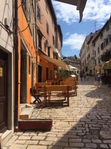 a group of wooden benches sitting on a street at Apartment Oaza in Rovinj