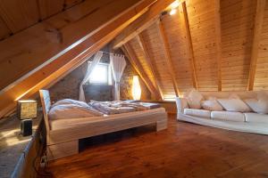 Habitación con cama y sofá en el ático en Historisches Ferienhaus "Zur Linde", en Hausten