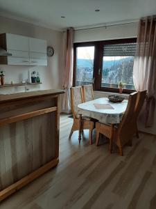 cocina con mesa, sillas y fregadero en Ferienwohnung Waldblick, en Hallenberg