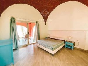 sypialnia z łóżkiem i dużym oknem w obiekcie FabbricaCasa Sea Front Villa, Oriental Coast w Marsa Alam
