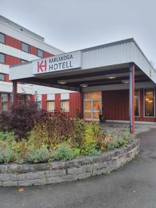 un hôtel avec un panneau à l'avant d'un bâtiment dans l'établissement Karlskoga Hotell & Konferens, à Karlskoga