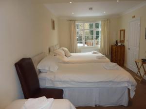 a bedroom with two beds and a chair and a window at Leverton House in Cambridge