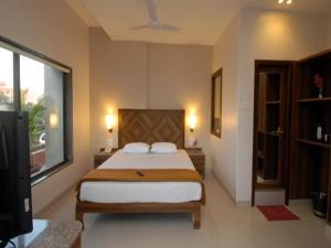 a bedroom with a bed and a large window at Sai Palace Budget Hotel in Shirdi