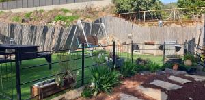 a fence in a garden with a playground at Zug Yonim in Livnim