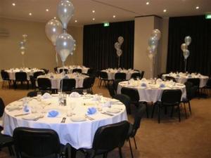 une salle de banquet avec des tables blanches et des ballons dans l'établissement Collie Ridge Resort, à Collie
