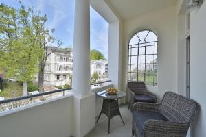 een balkon met 2 stoelen, een tafel en ramen bij Strandnahe Ferienwohnung 6 Villa Celia in Ostseebad Sellin