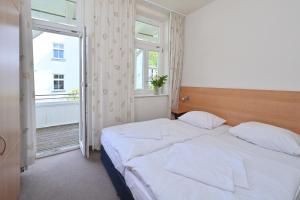 een slaapkamer met een groot bed en een raam bij Strandnahe Ferienwohnung 6 Villa Celia in Ostseebad Sellin