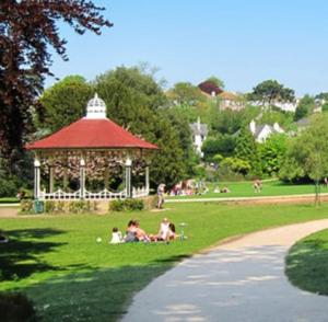 people sitting on the grass in a park with a gazebo at Home from home in Hastings