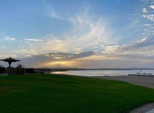una vista de una playa con la puesta de sol en el fondo en FabbricaCasa Sea Front Villa, Oriental Coast, en Marsa Alam