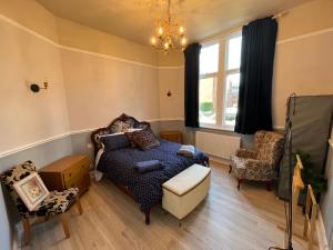 a bedroom with a bed and a chair and a window at Red Gables - Ground Floor in Carlisle