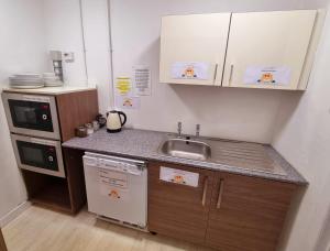 a small kitchen with a sink and a dishwasher at Premier Lodge in Falkirk