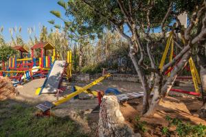 a playground with colorful playground equipment in a park at Iliostasi Beach Apartments in Hersonissos