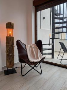 una silla negra sentada en una habitación con ventana en View 4 U Apartment - Alicante, en Alicante