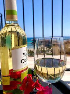 Una botella de vino junto a una copa en View 4 U Apartment - Alicante, en Alicante