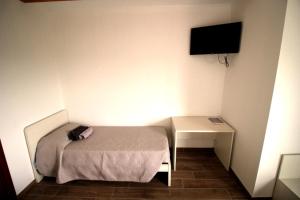una piccola camera da letto con un letto e una scrivania di B&B Ca' Bianca ad Adria