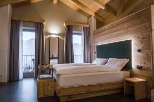 een slaapkamer met een groot bed in een kamer met ramen bij ALPS LOVER in Campodenno