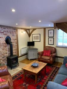 a living room with a couch and a wood stove at Stable Cottage in Dorking