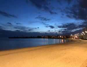 - une plage la nuit avec des lumières sur l'eau dans l'établissement La Real Arrecife, à Arrecife